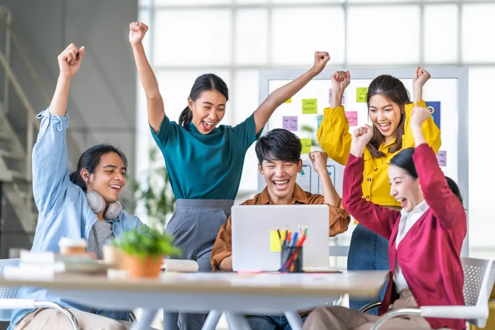 Young happy Asian business man, woman work together, celebrate success in start up office