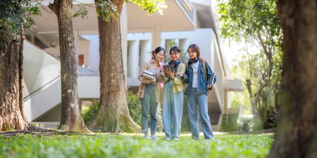 Happy young students chat with each other after class. Guys and girls wear casual clothes to study