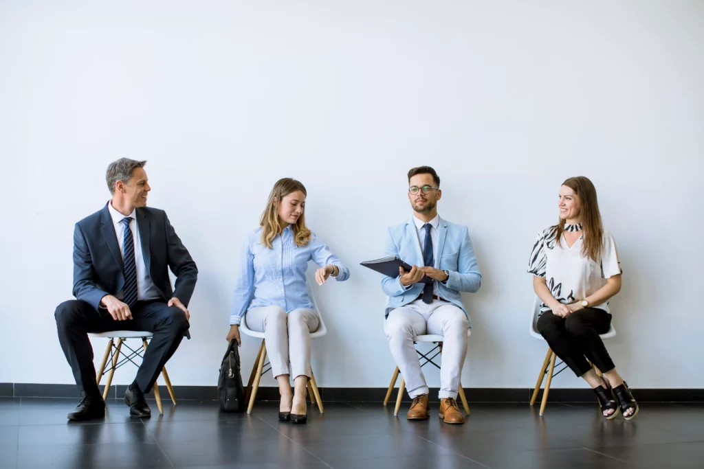 Four people sitting in a waiting room before a job interview